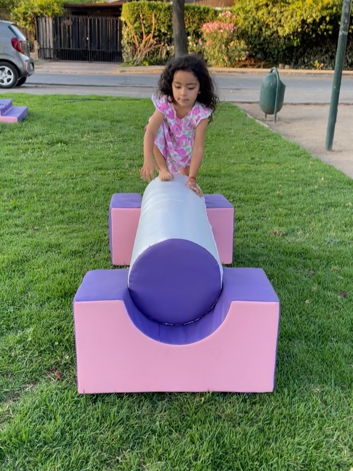 Niña jugando sobre el túnel de equilibrio de una plaza blanda Babylia